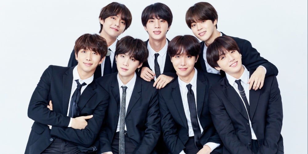 [Image Description: BTS posing for a group photoshoot wearing black formal suits and ties. Top row: V, Jin, Jimin Bottom Row: RM, Suga, J-Hope, Jungkook Source: AllKPop]