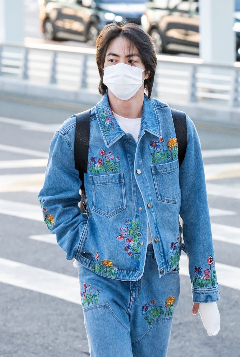 BTS' Jin waves for cameras at airport