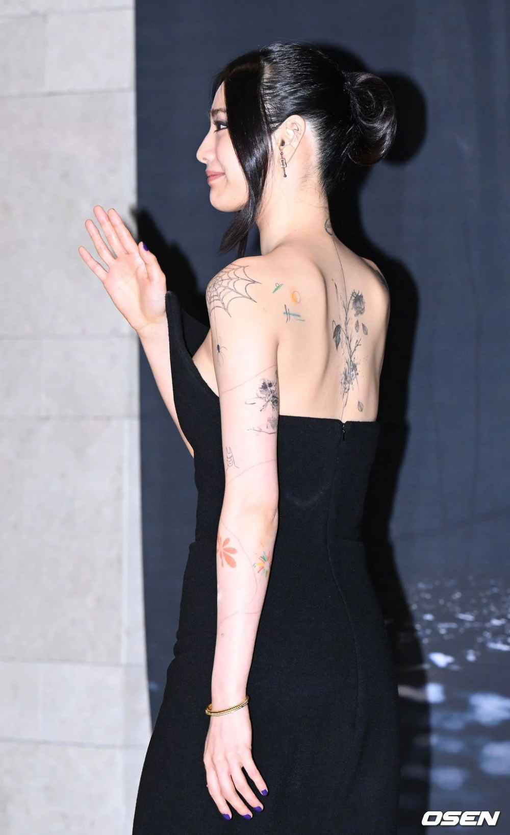 Nana boldly shows off more tattoos at the VIP screening event for the