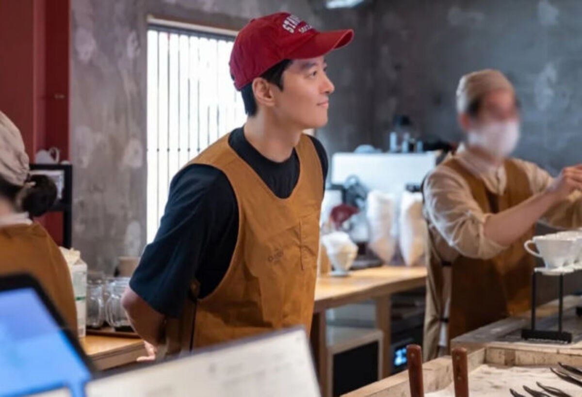 Lee Dong Gun menunjukkan senyum cerah di tengah kesuksesan kafe meskipun ada ketegangan lingkungan