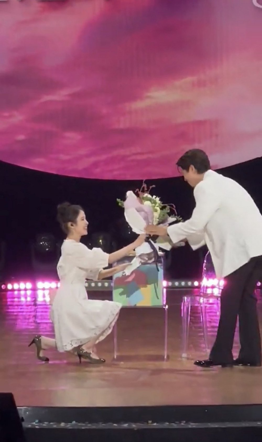 IU berlutut memberikan bunga kepada Park Bo Gum
