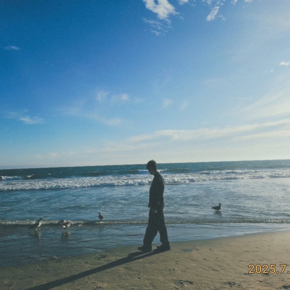 Jimin, RM, dan j-hope BTS berpose bersama di pantai, menunjukkan keakraban.